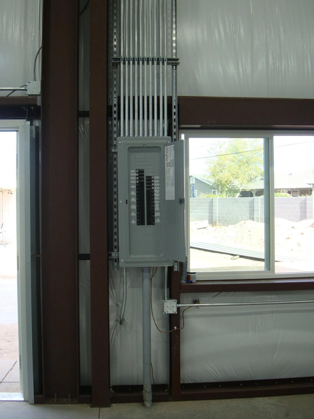 New breaker panel with a bank of conduit inside a metal building