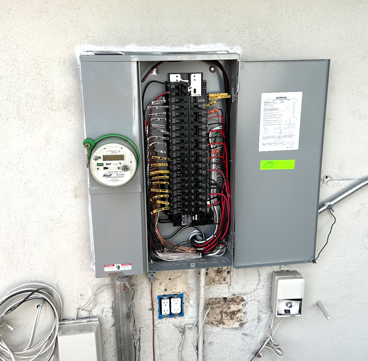A new Siemens electrical panel with labeled breakers next to an SRP meter on a stucco wall