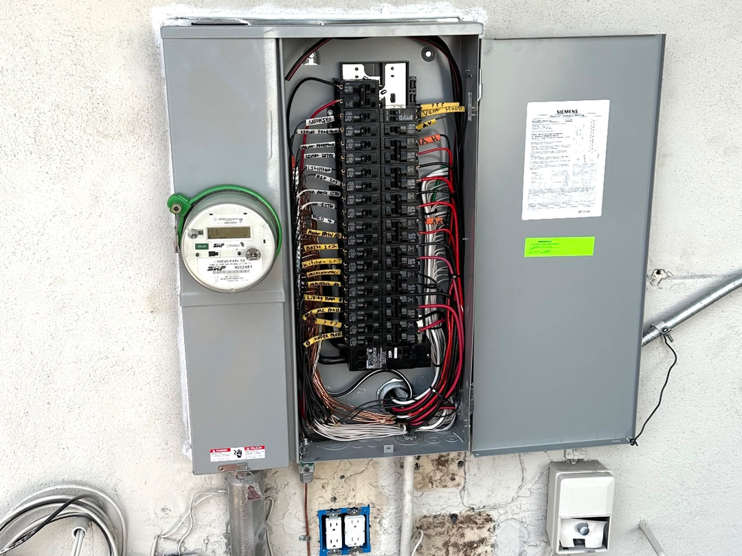 A new Siemens electrical panel with labeled breakers next to an SRP meter on a stucco wall