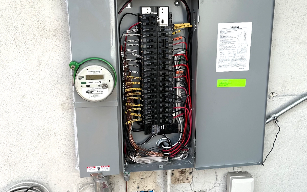 A new Siemens electrical panel with labeled breakers next to an SRP meter on a stucco wall