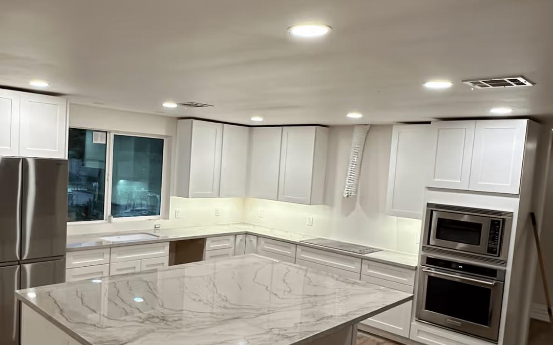 A remodeled kitchen at night lit by recessed ceiling lights