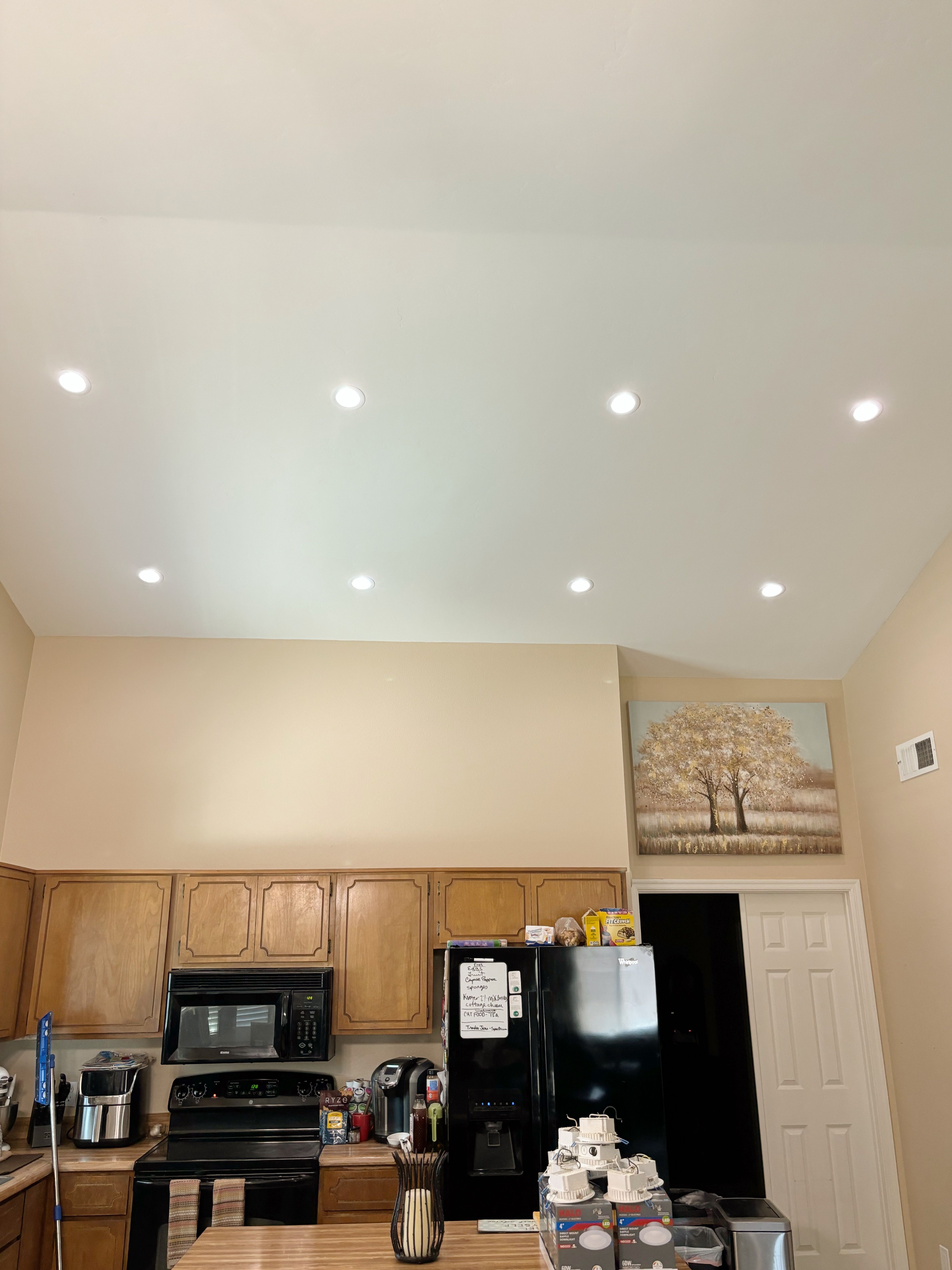 New recessed lights glowing in a vaulted kitchen ceiling