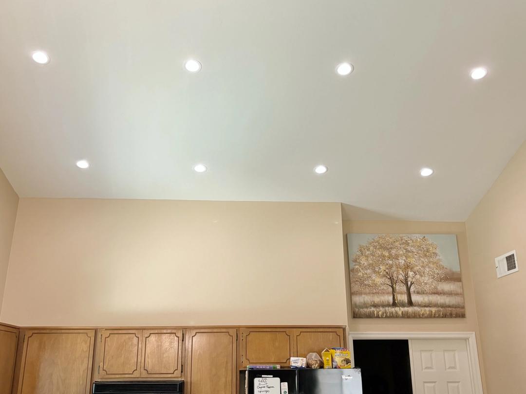 New recessed lights glowing in a vaulted kitchen ceiling