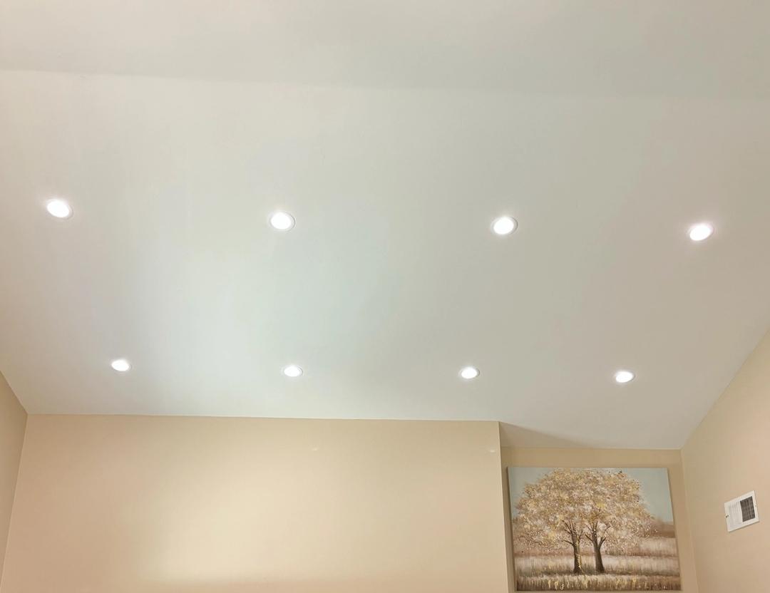 New recessed lights glowing in a vaulted kitchen ceiling