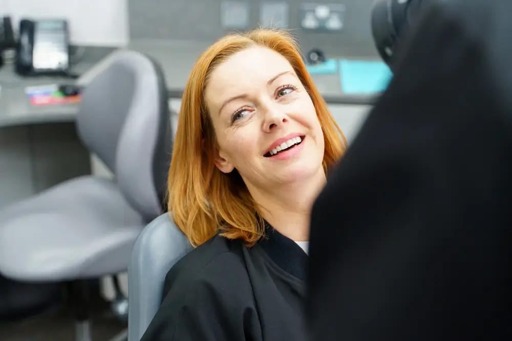 A female patient in a chair, smiling