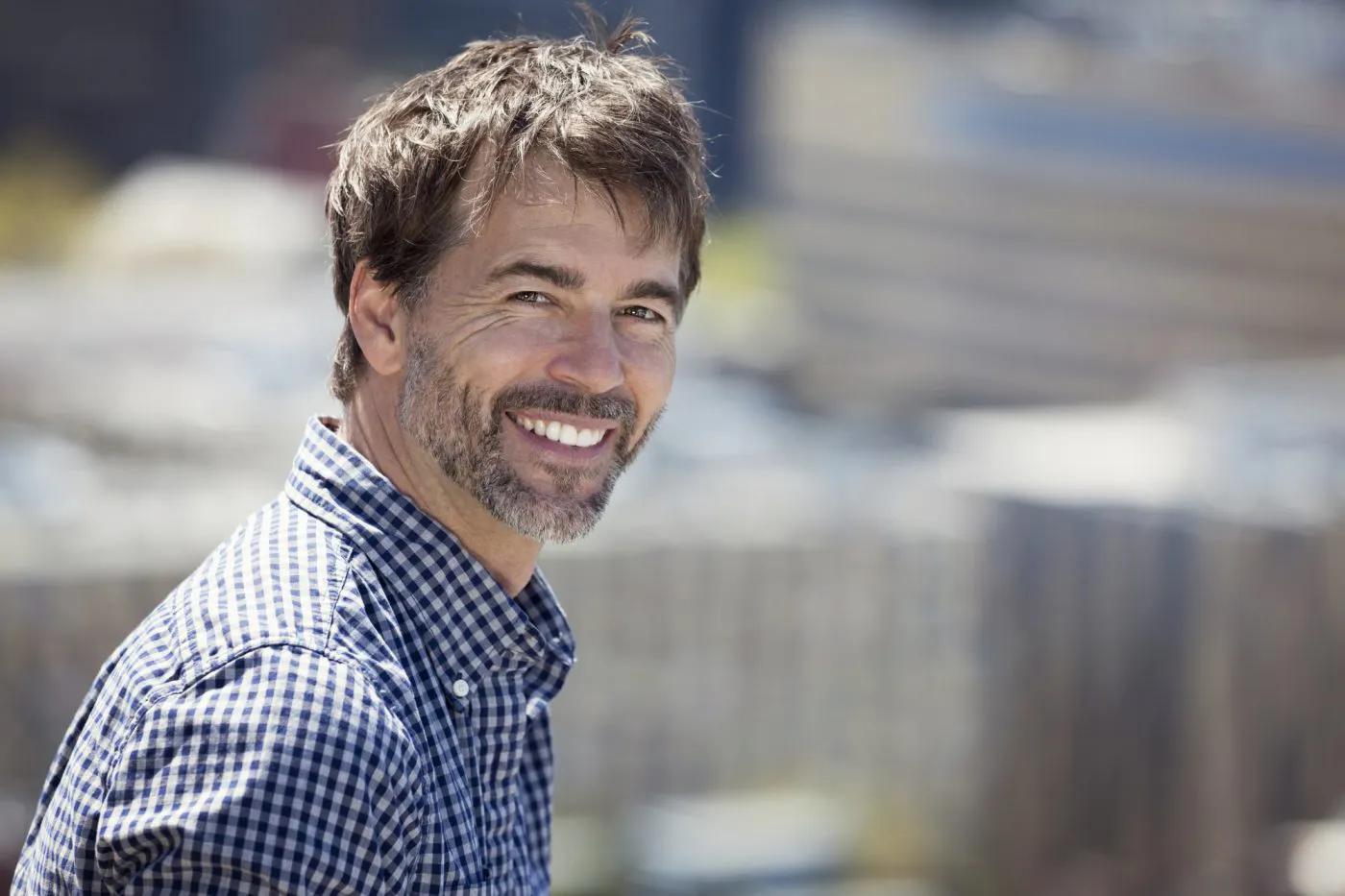 Image of a man in a blue checked shirt smiling