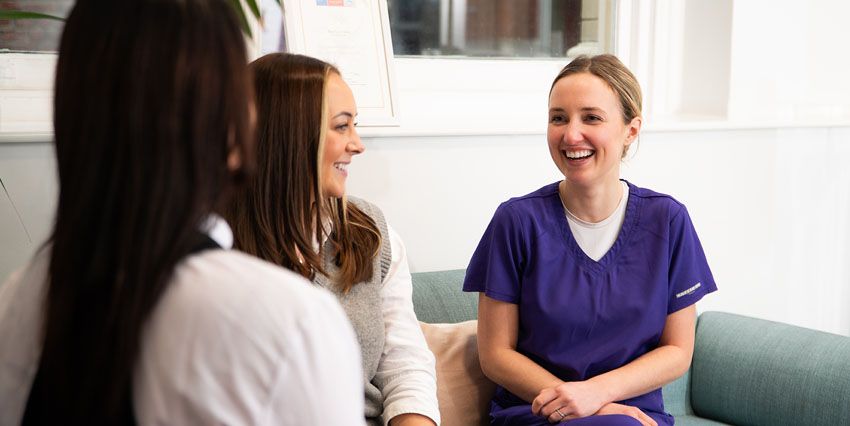 Dental nurse chatting in reception to patient