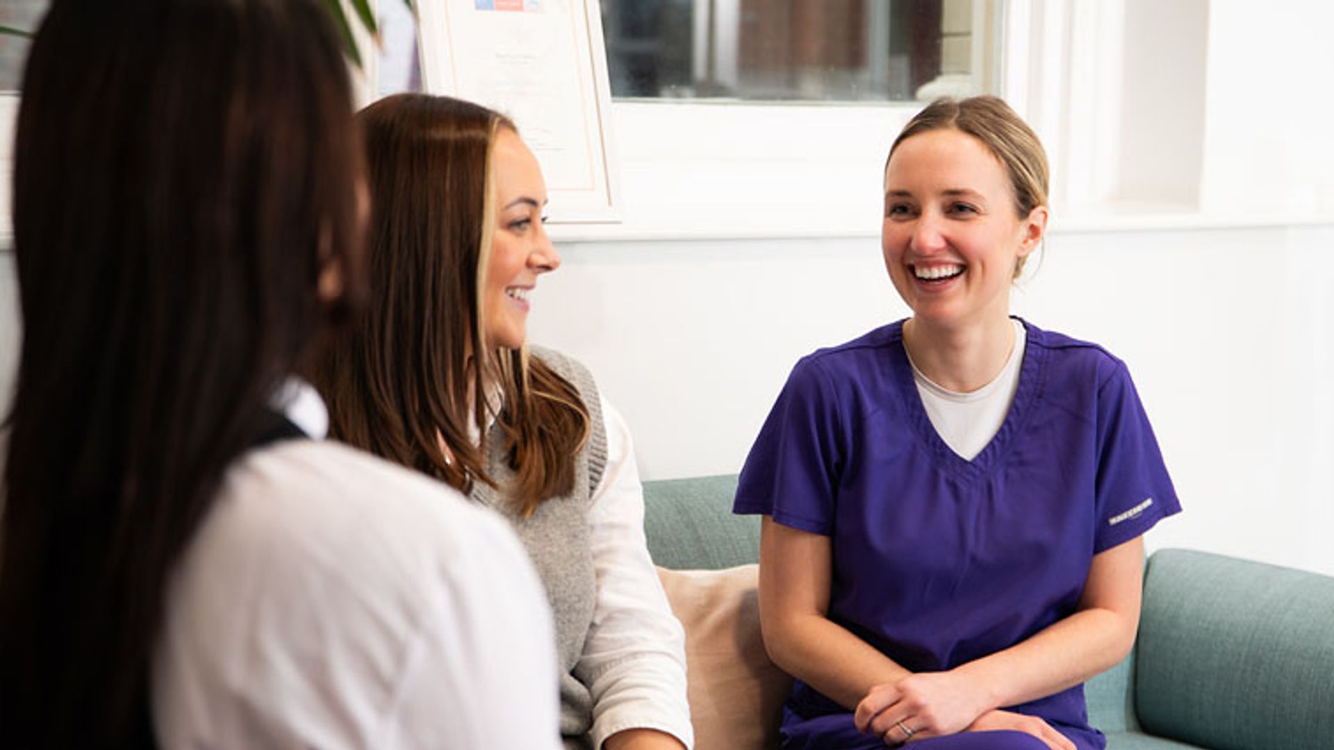 Dental nurse chatting in reception to patient