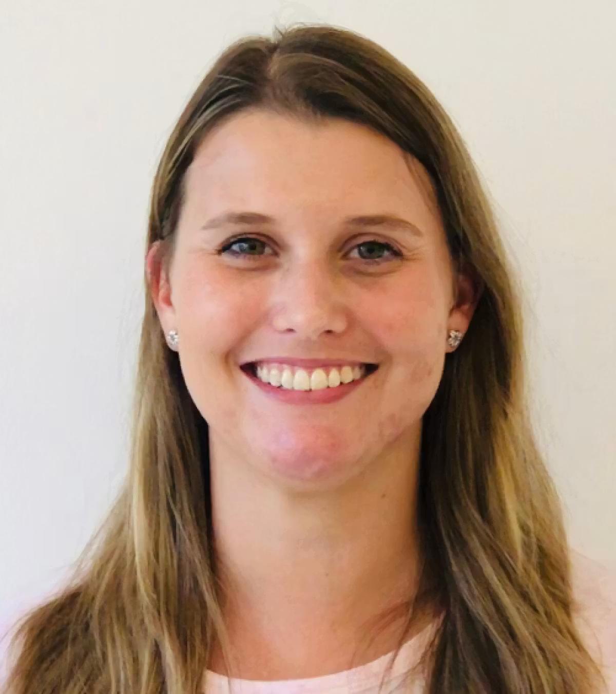 Image of a woman facing the camera and smiling with her teeth showing