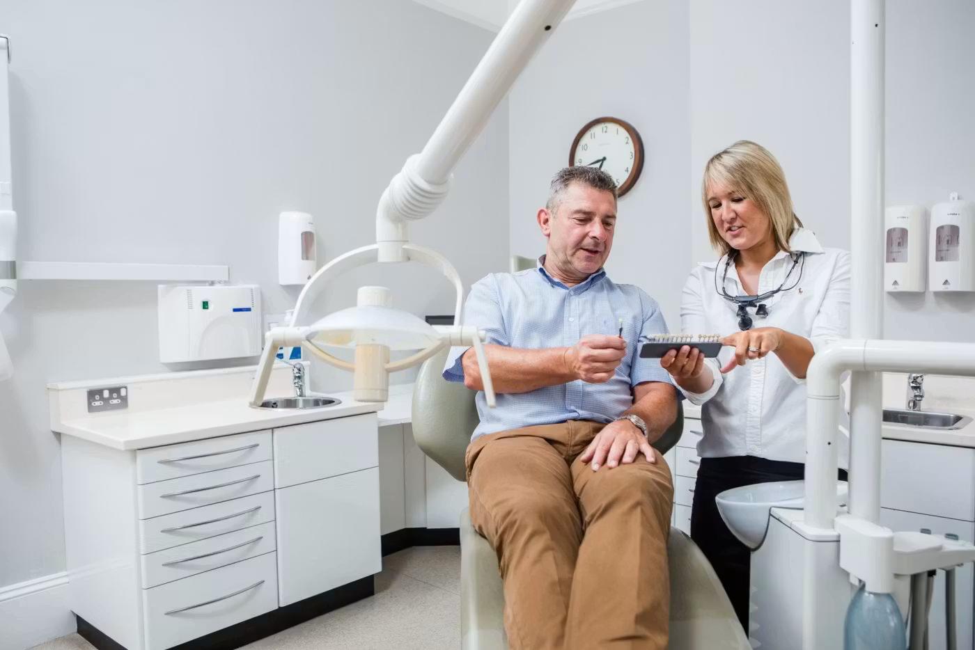 Dentist showing a patient a dental model in the surgery