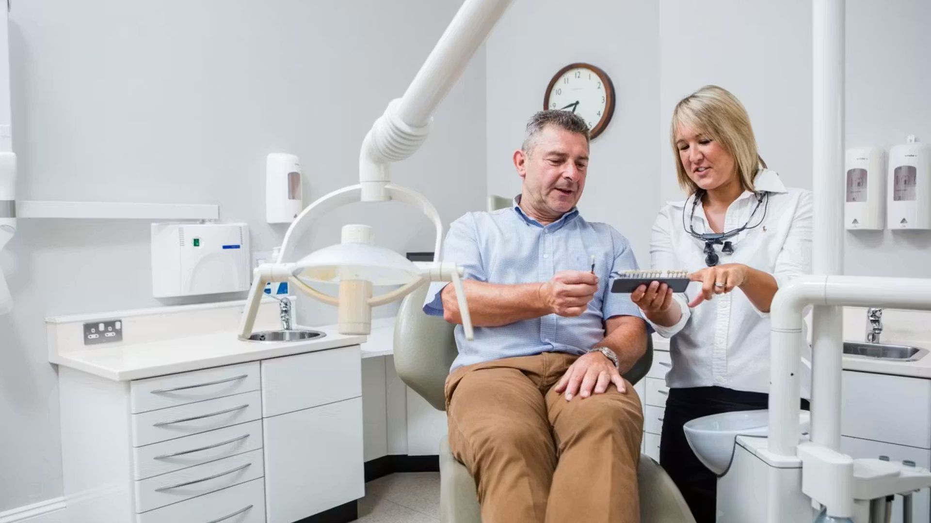 Dentist showing a patient a dental model in the surgery