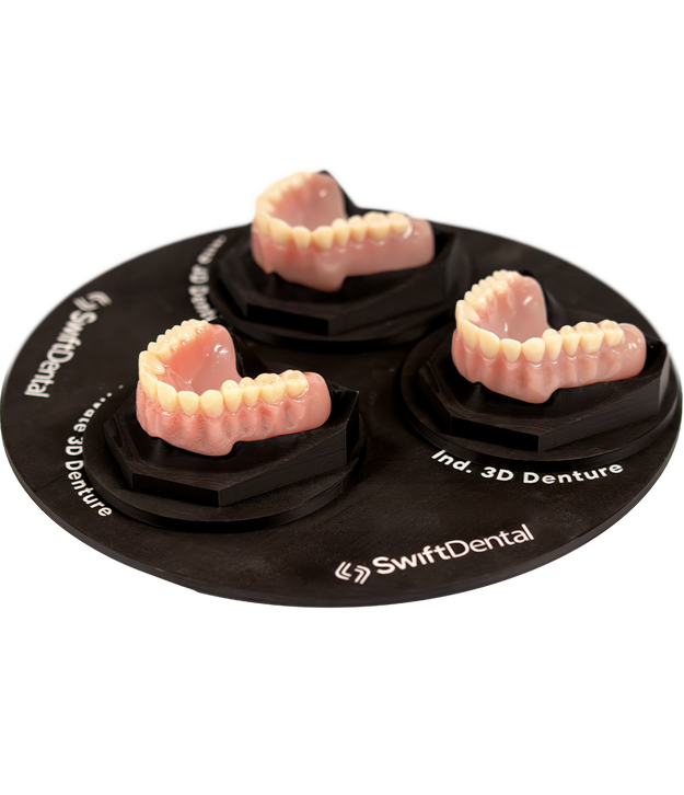 Three complete denture prosthetics manufactured using 3D printing technology displayed on a black SwiftDental demonstration base, showcasing maxillary and mandibular denture options.