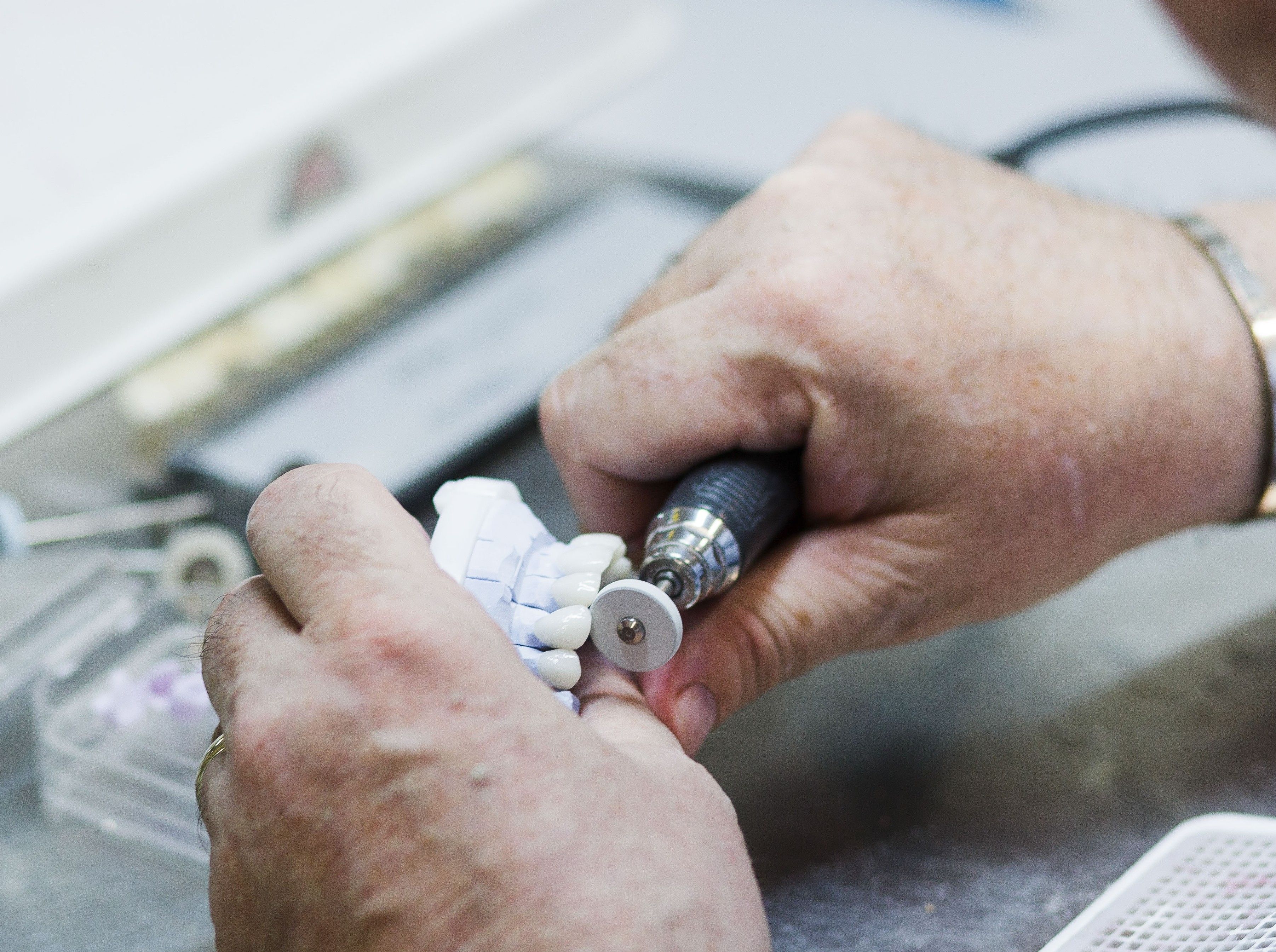 hands crafting a denture
