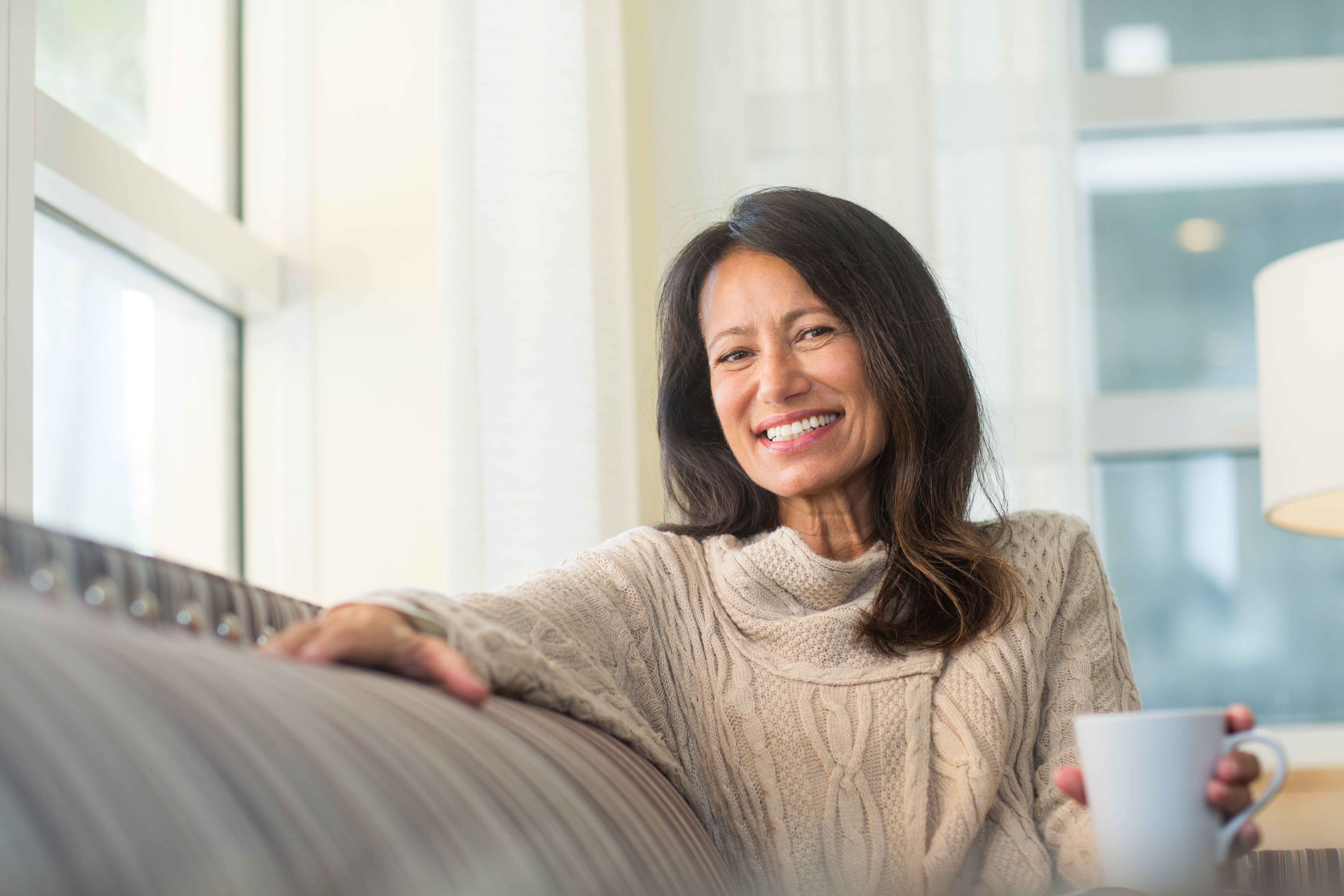 elderly lady smiling holding a cup of tea