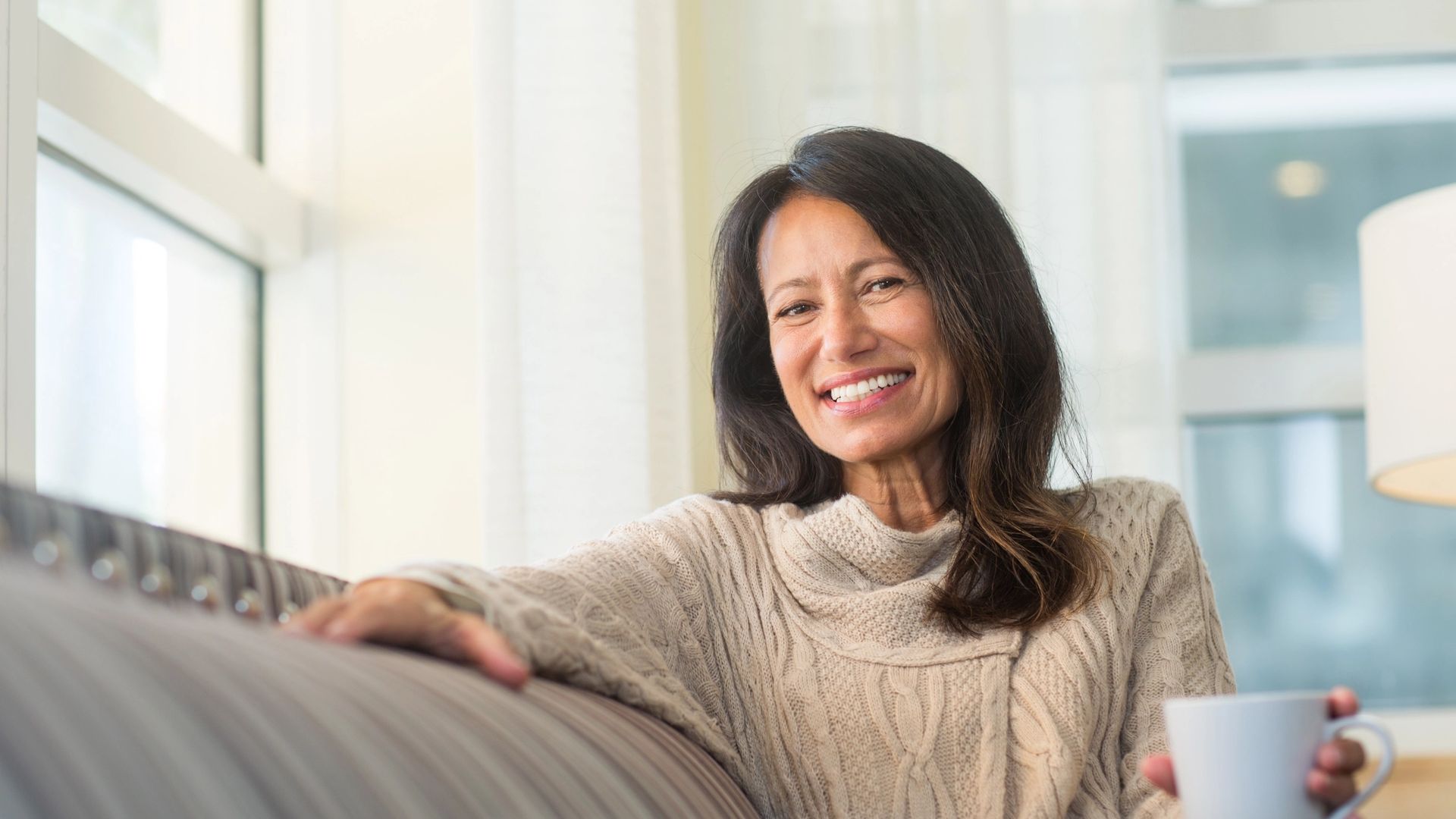 elderly lady smiling holding a cup of tea