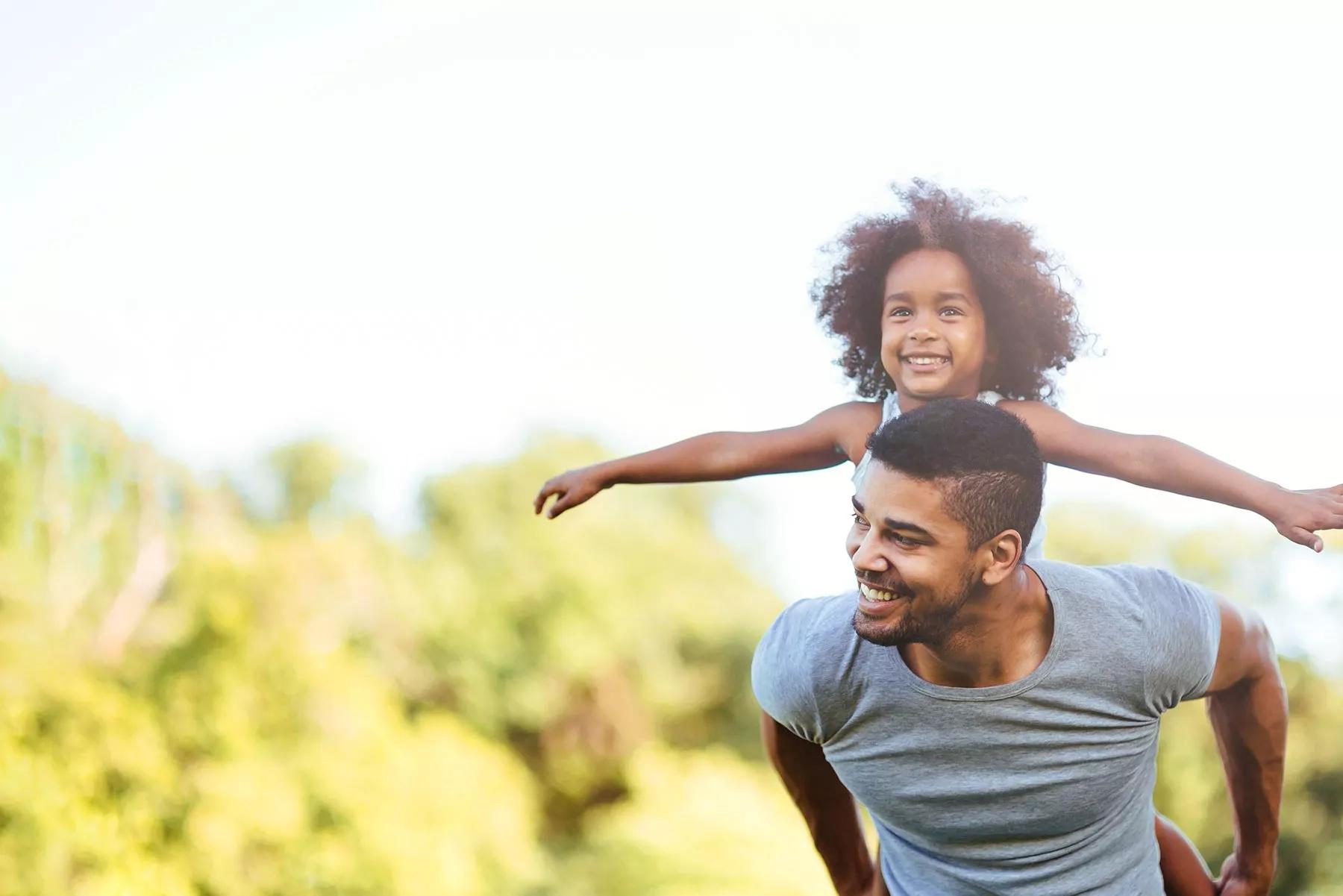 Adult and child family smiling outdoors