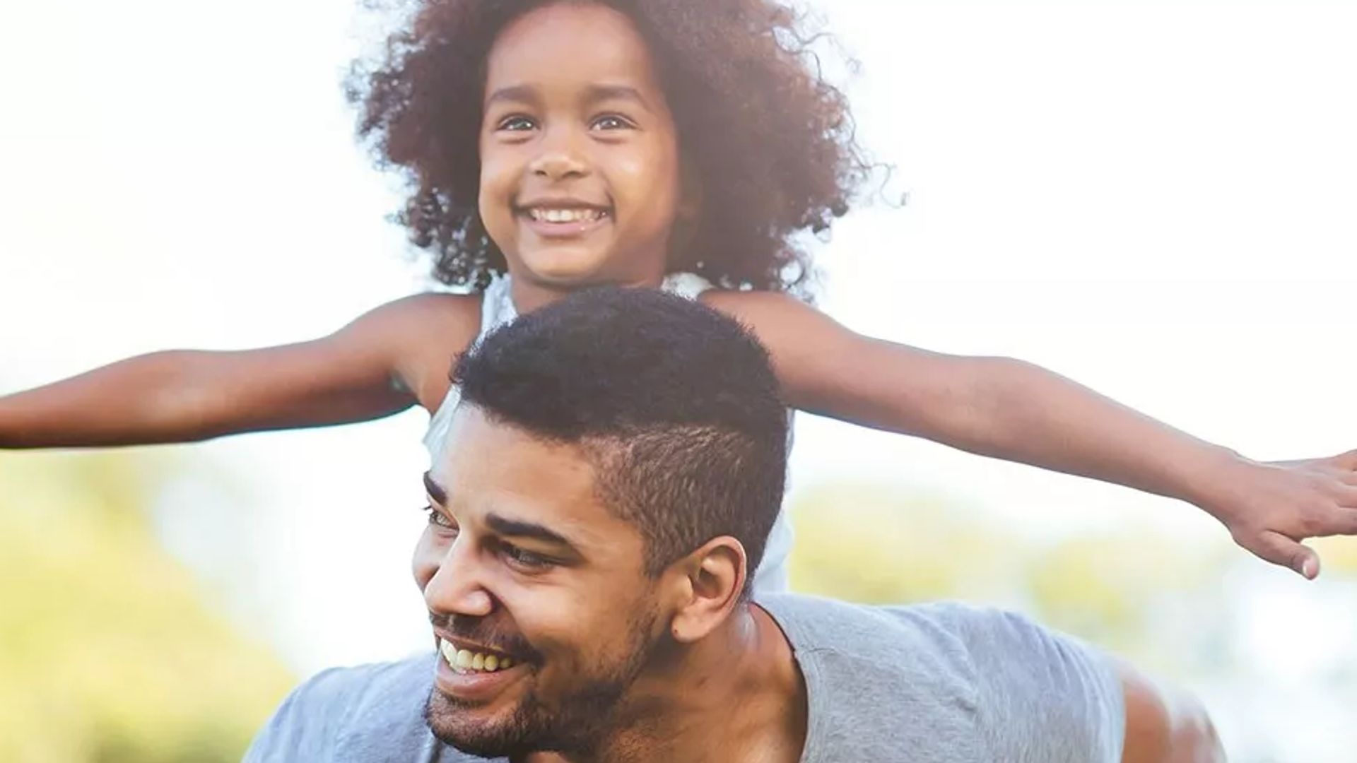 Adult and child family smiling outdoors