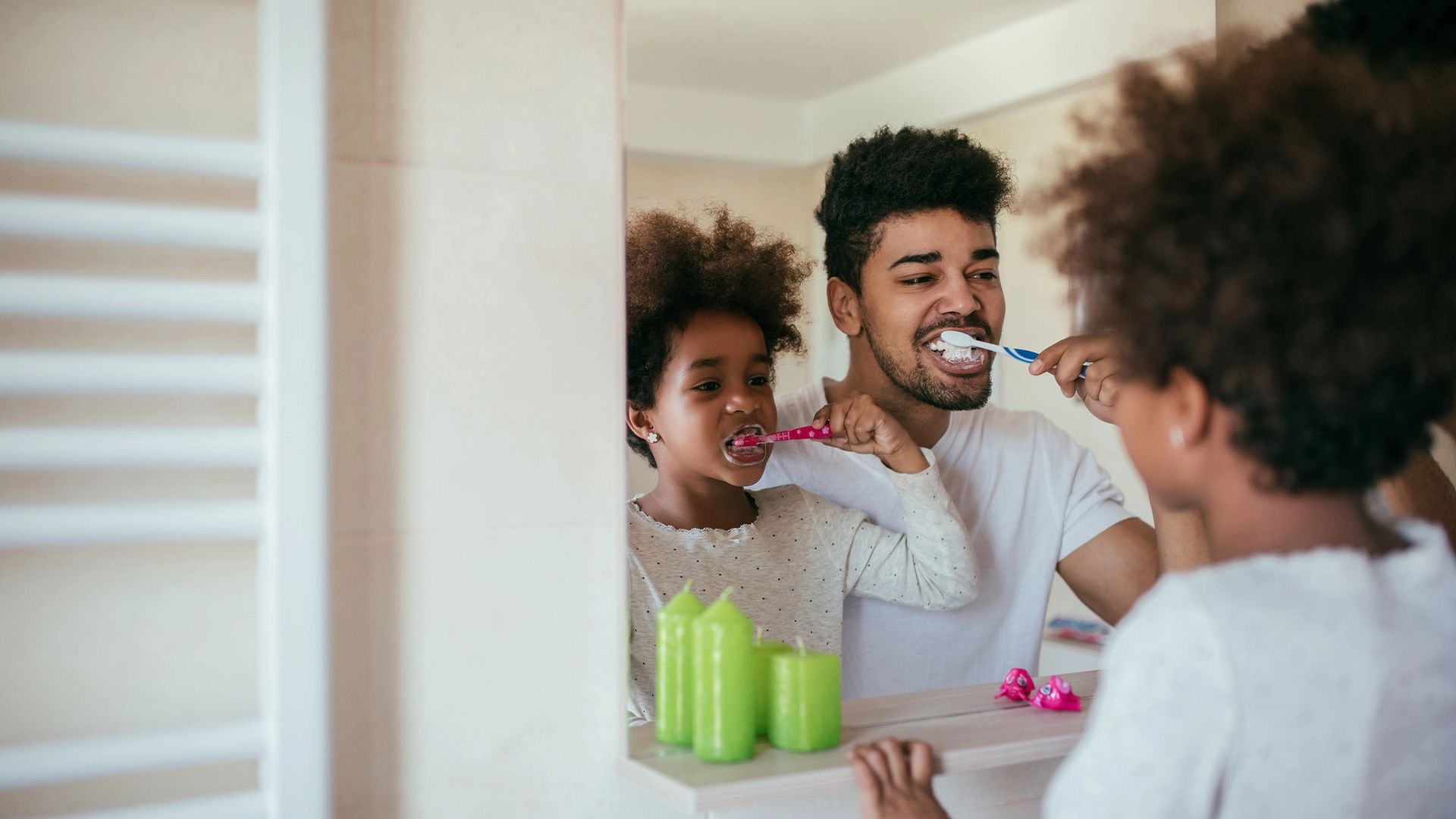 family brushing their teeth in mirror