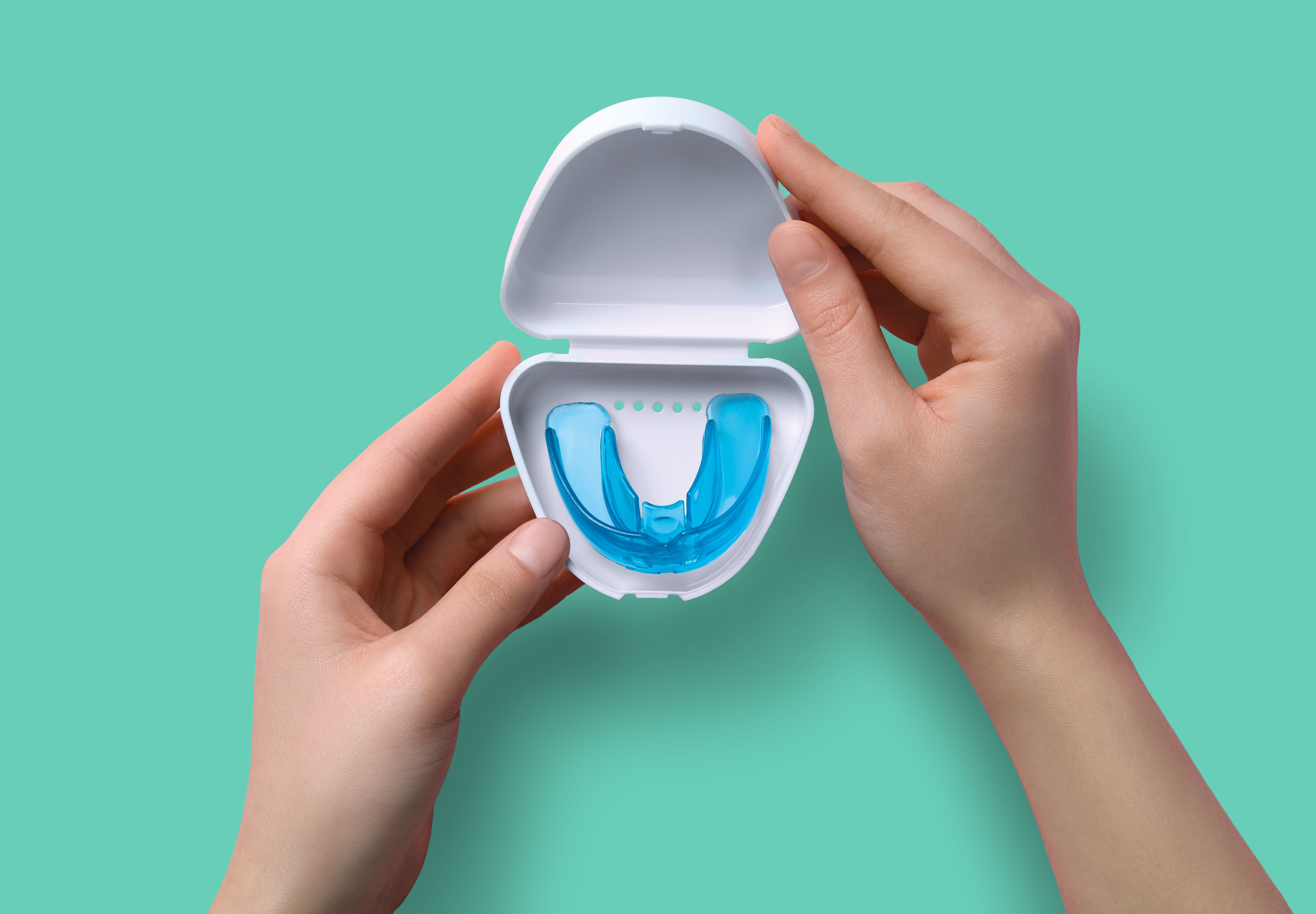 hands holding mouthguard in a case