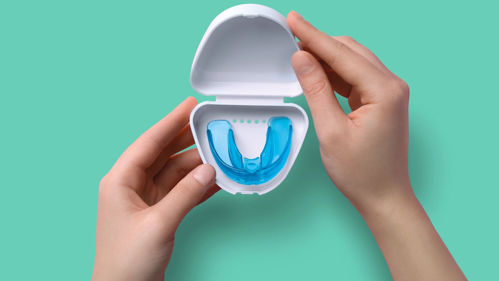 hands holding mouthguard in a case