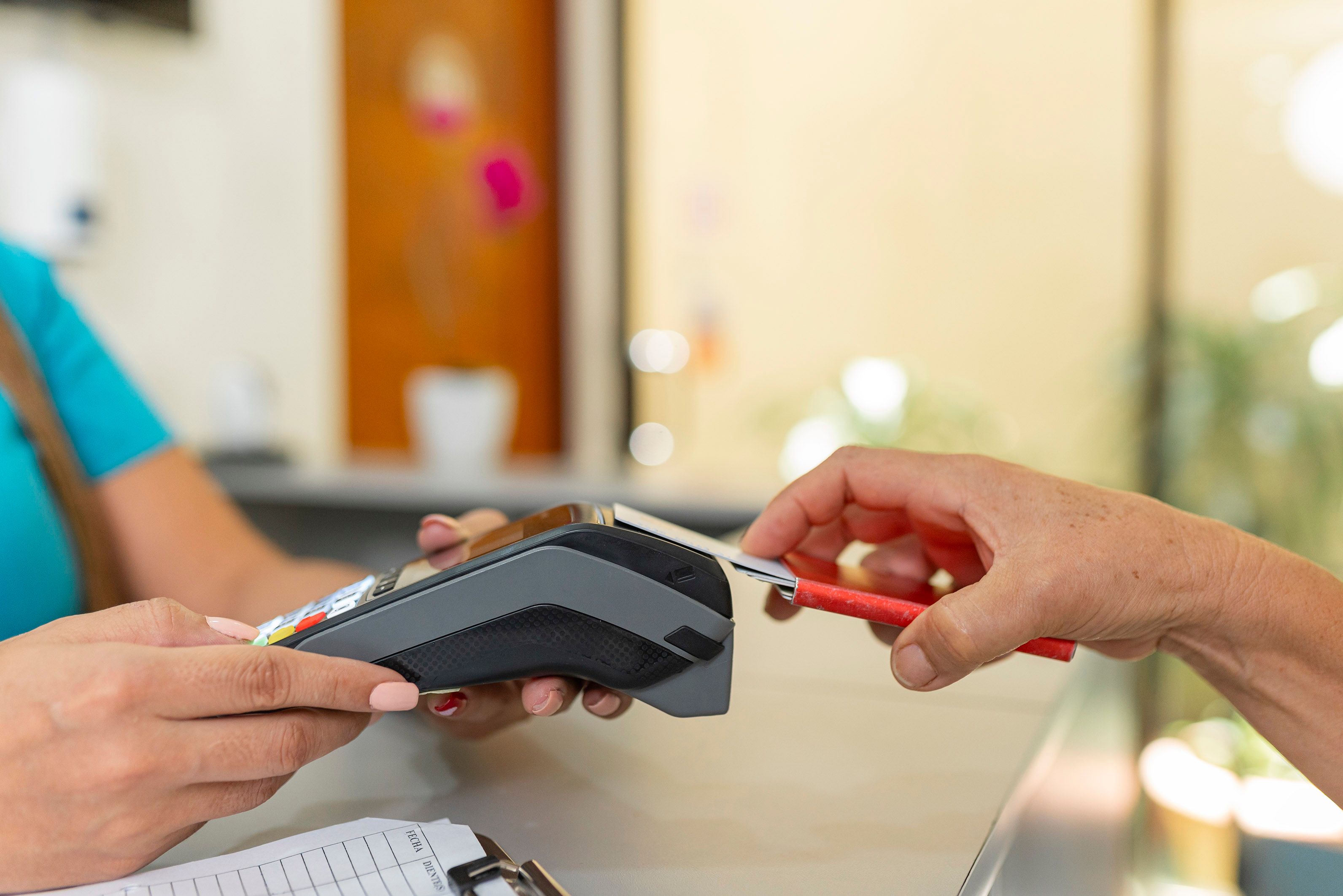 person paying with a card on a card machine