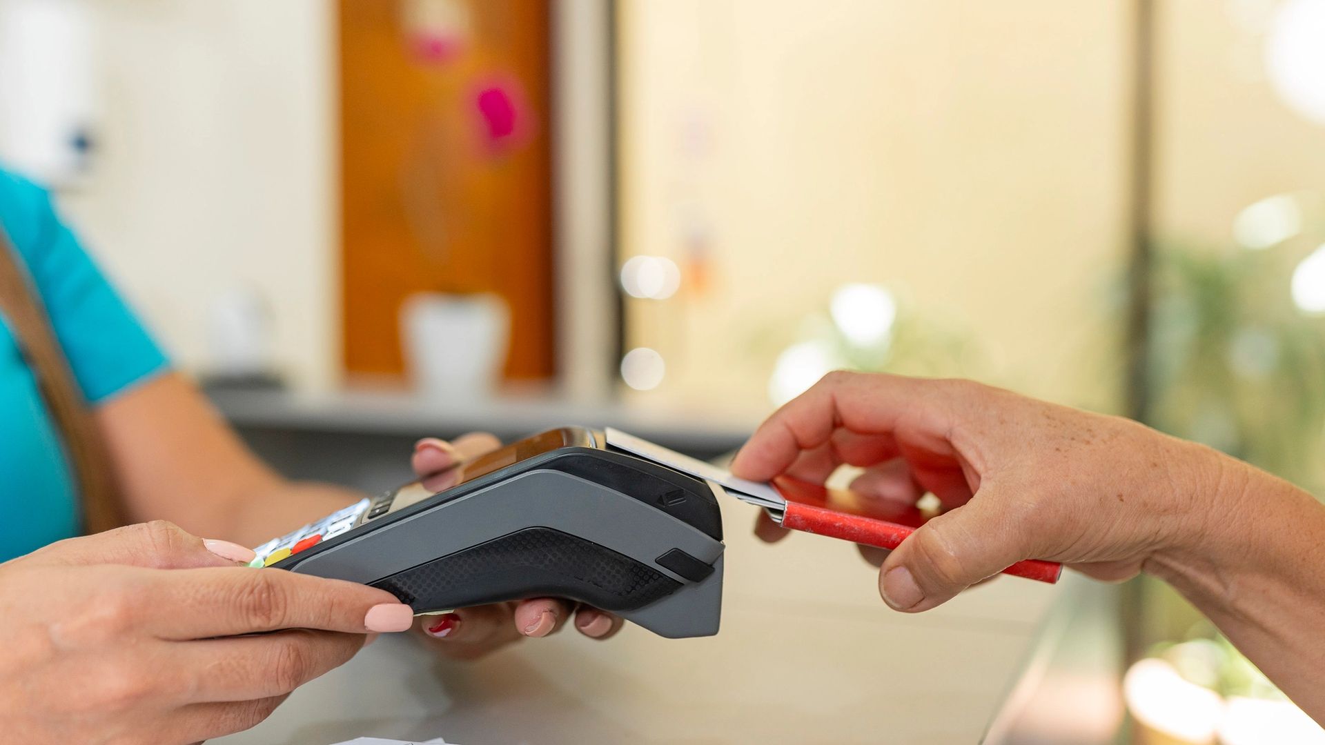 person paying with a card on a card machine