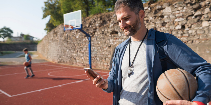 basketball coach looking at phone