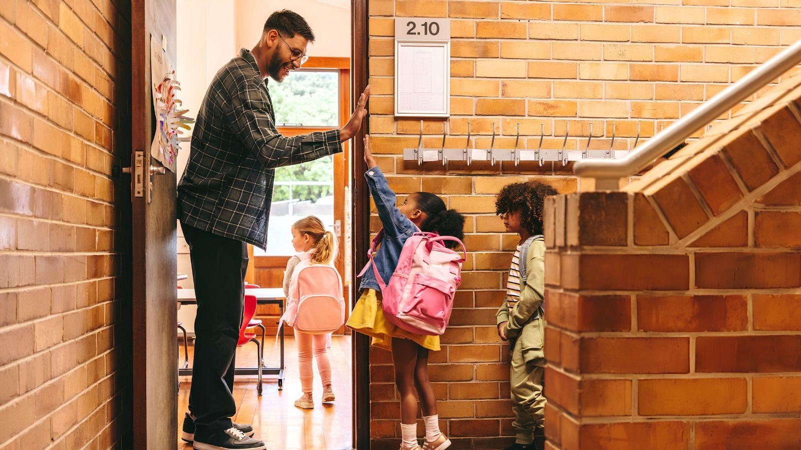 teacher welcoming students to class