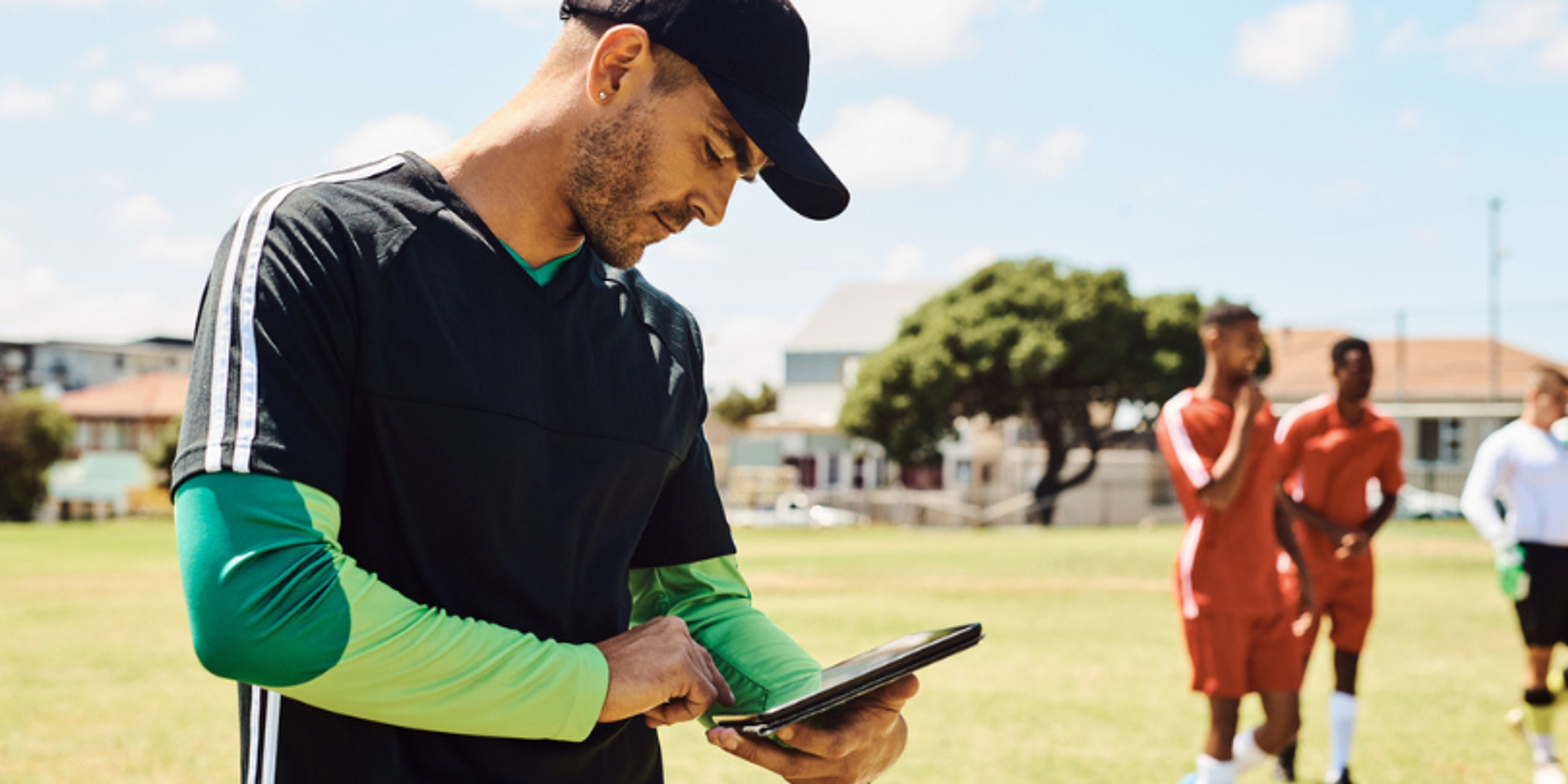 youth sports coach looking at tablet
