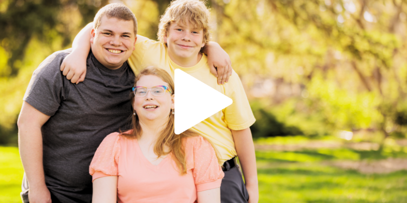 Group of special needs children share a hug and a smile in natural light.