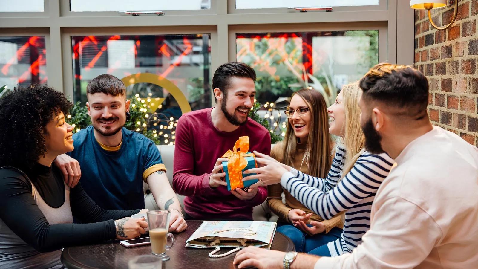 people giving a group gift to a friend