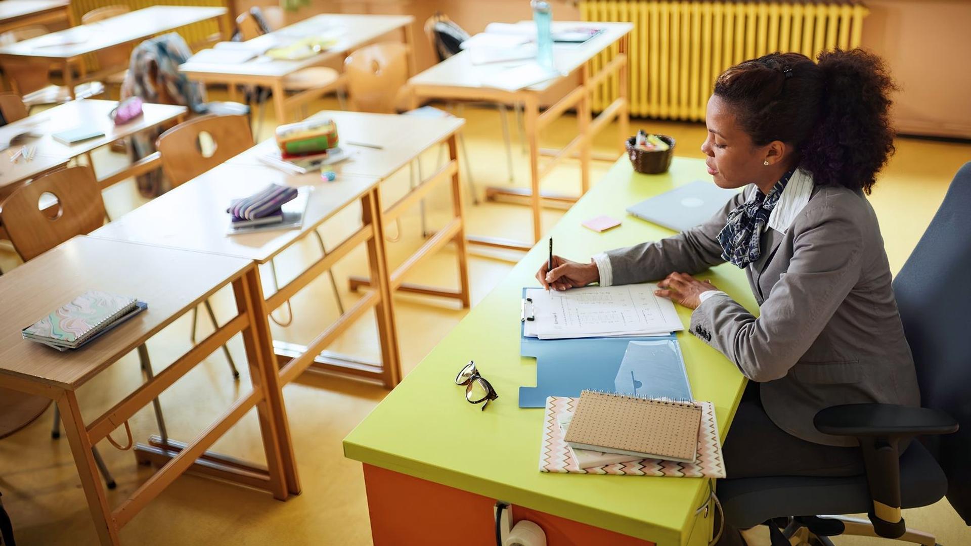 teacher sitting at a desk planning