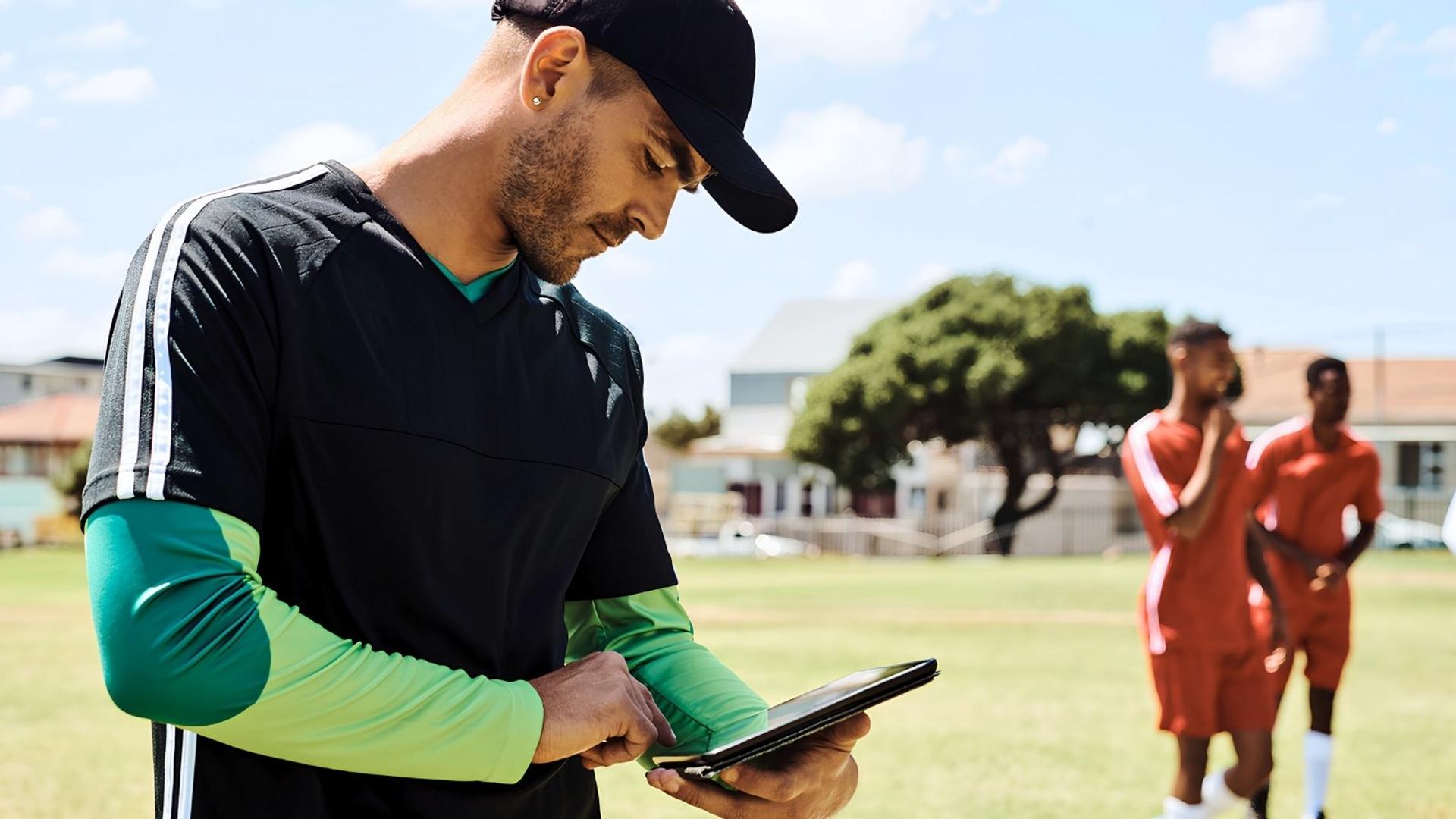 youth sports coach looking at tablet