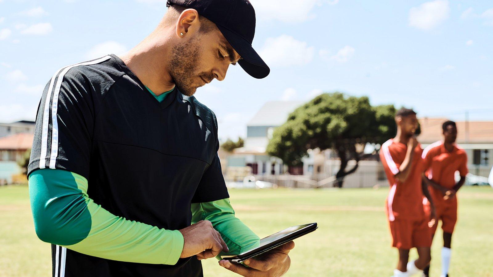 youth sports coach looking at tablet