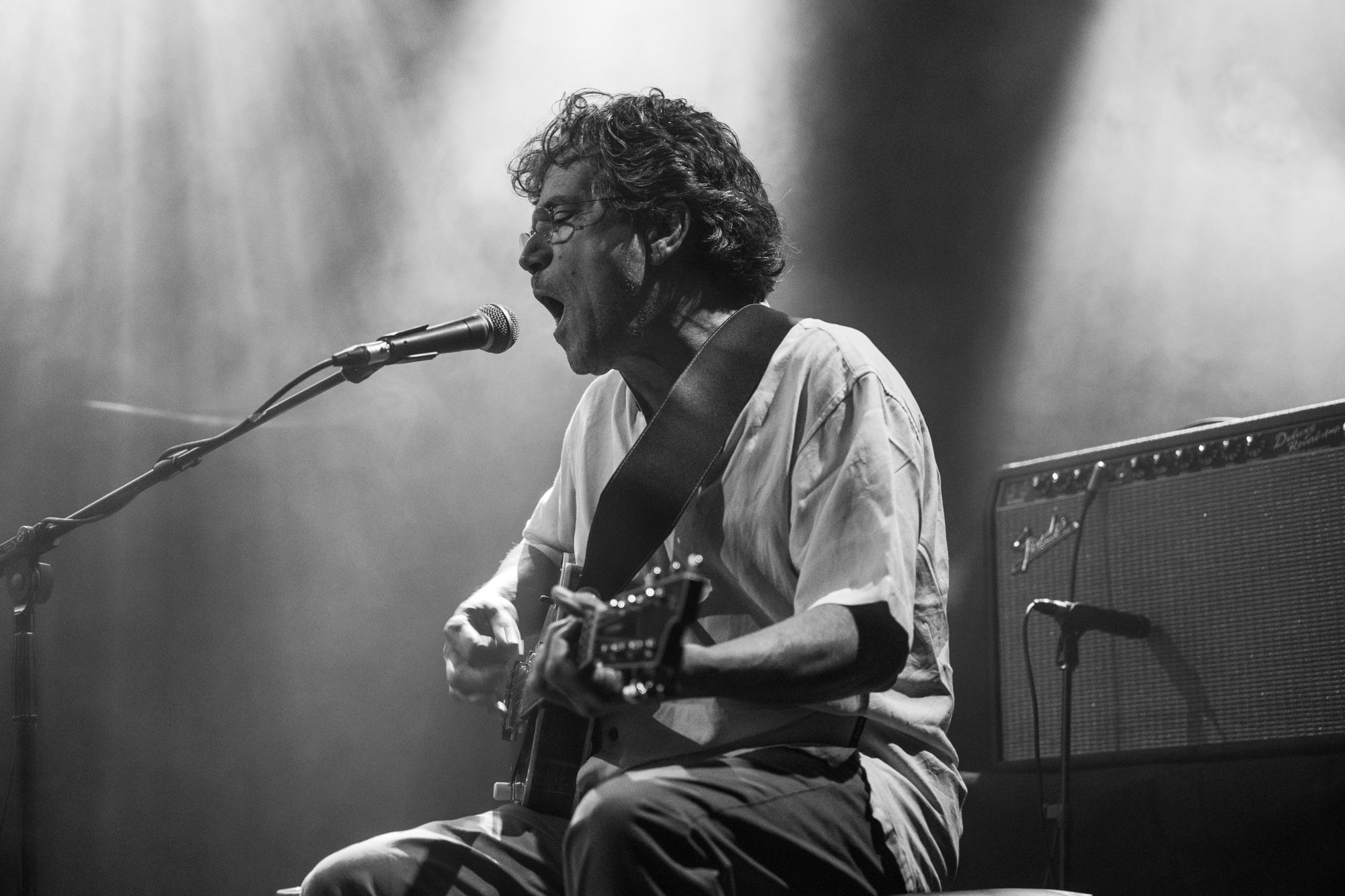 René Lussier singing and playing guitar in a black and white photograph.