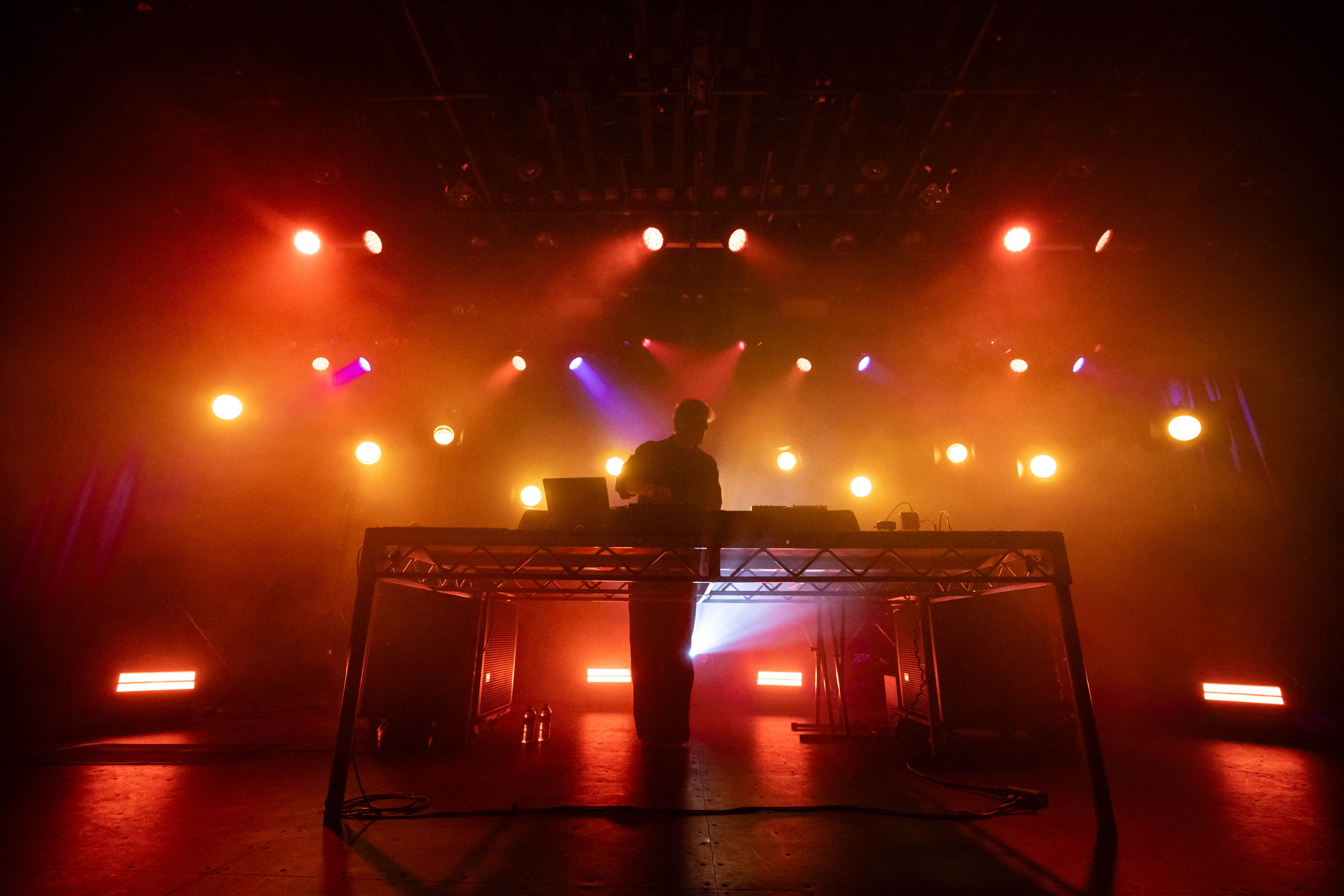 Many red and yellow lights backlight Christian Löffler on the stage of the Commodore Ballroom