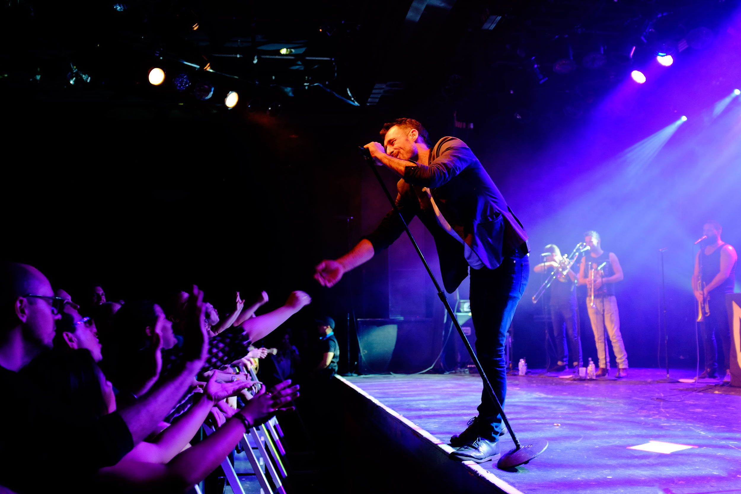 Felix Riebl of the Cat Empire reaches out his arm to fans in the front row at the Commodore Ballroom in Vancouver