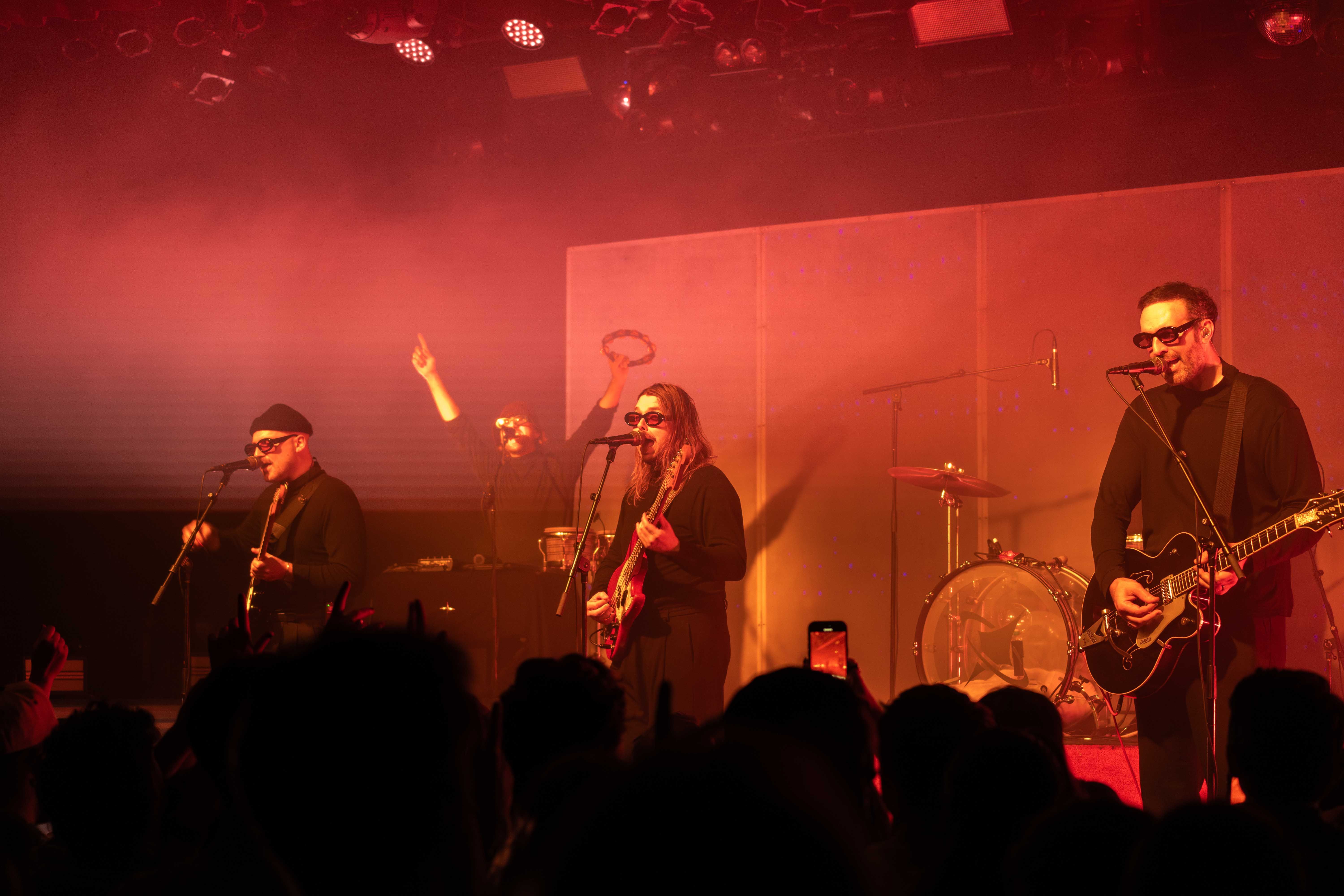 The band LEISURE performing on stage at the Commodore Ballroom under orange lights