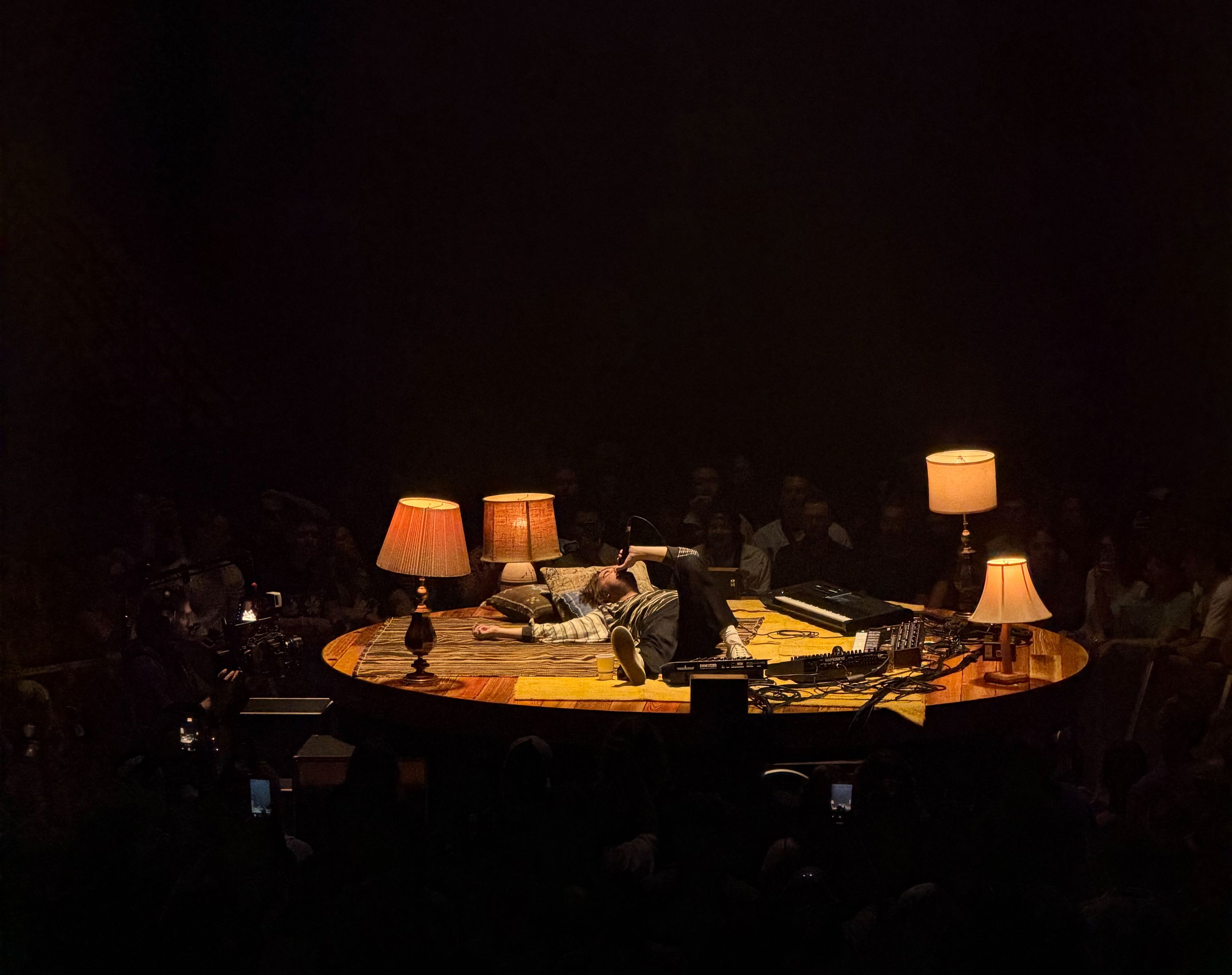 Tame Impala's Kevin Parker lies down on a small circular stage during a performance in Vancouver.