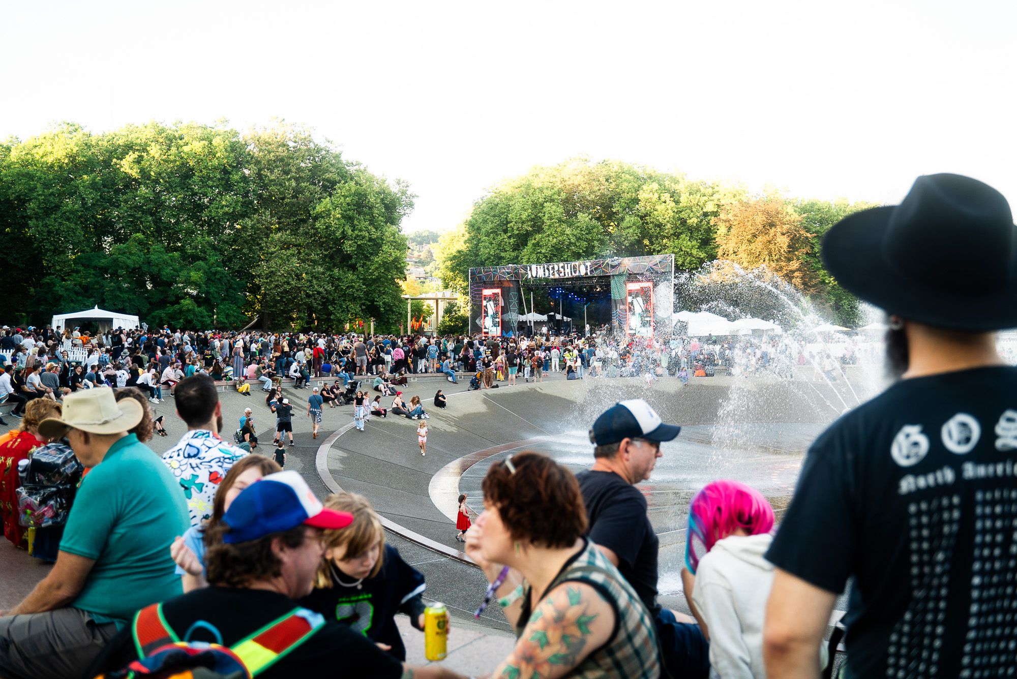 Attendees look over the park fountain towards the main festival stage.
