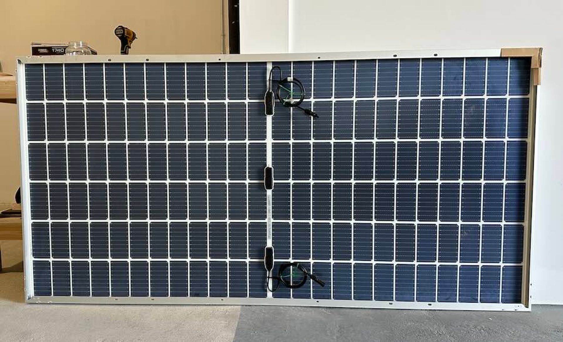 Photo of a solar panel's underside showing the frame and its pre-drilled holes