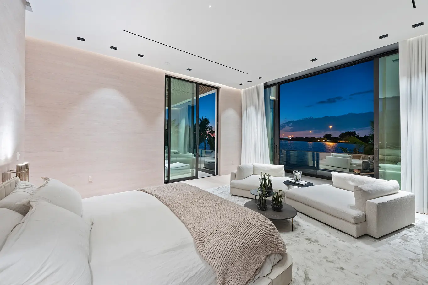 Serene master bedroom with floor-to-ceiling windows showcasing panoramic bay and city skyline views