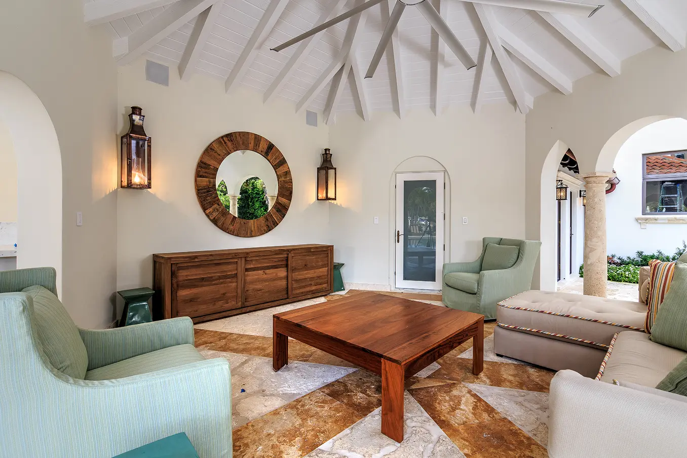 Open-concept living space seamlessly connecting interior and outdoor courtyard through floor-to-ceiling glass doors