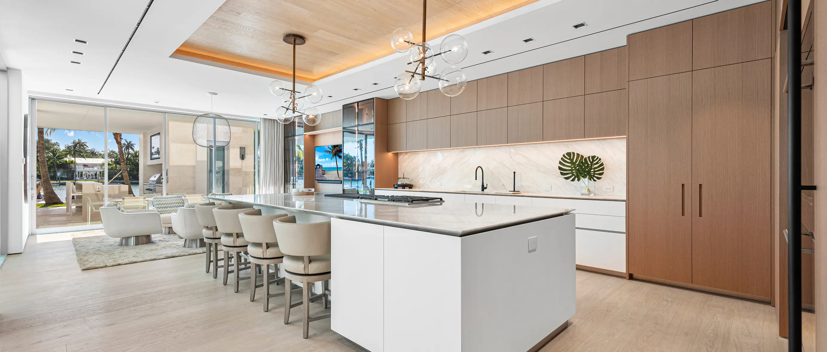 Gourmet kitchen with expansive marble island, professional appliances, and modern white cabinetry