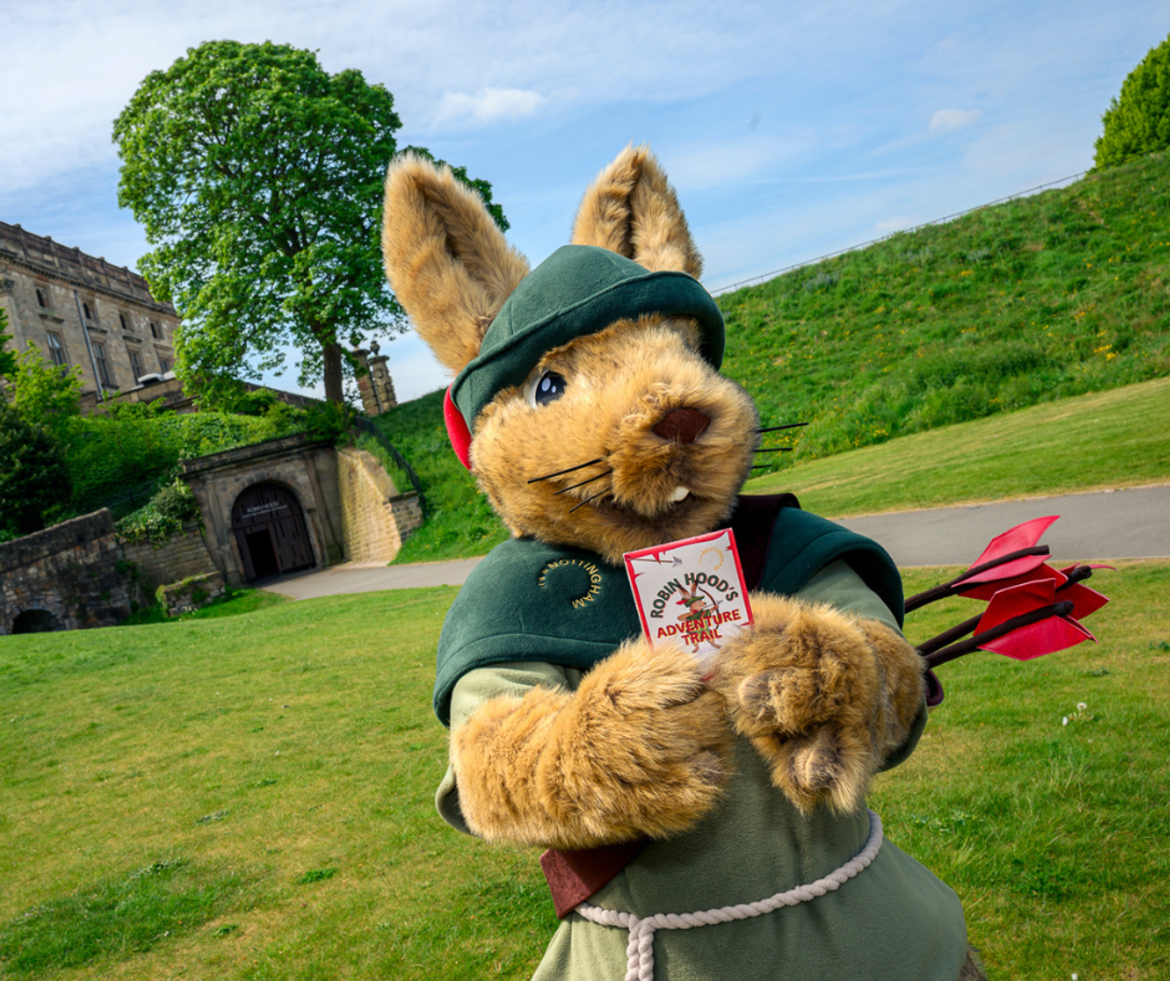 It's in Nottingham's Robin Hood Rabbit mascot holding Robin Hood's Adventure Trail maps in front of Nottingham Castle