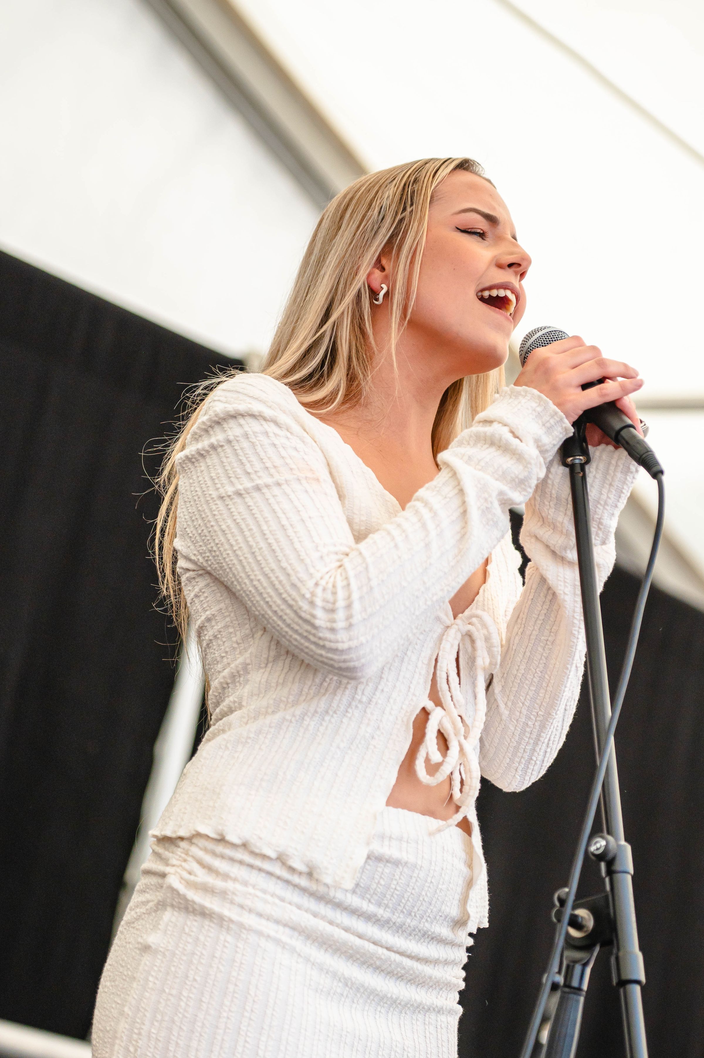 A young woman singing on stage