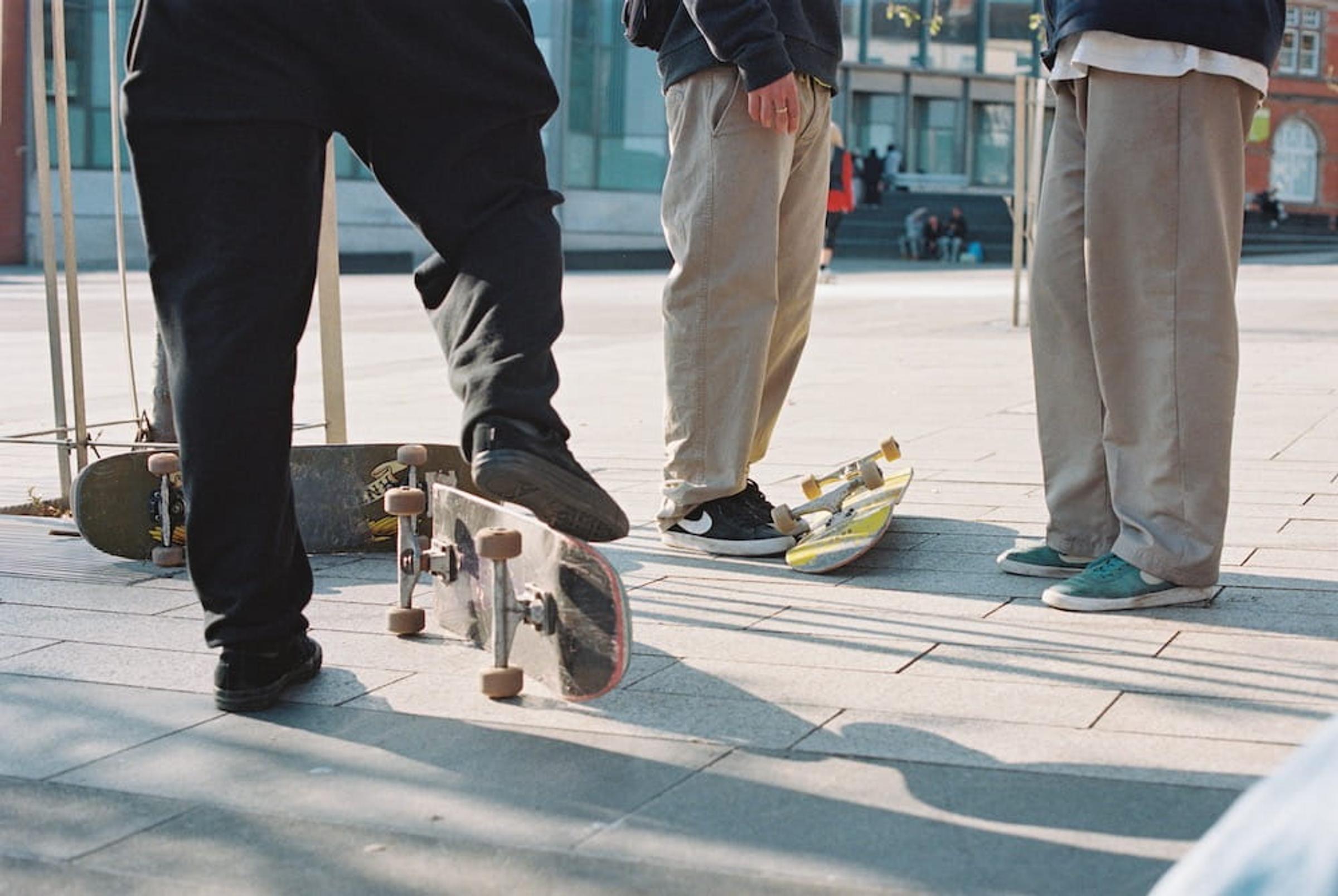 The legs and feet of three skateboarders stood in Nottingham city centre