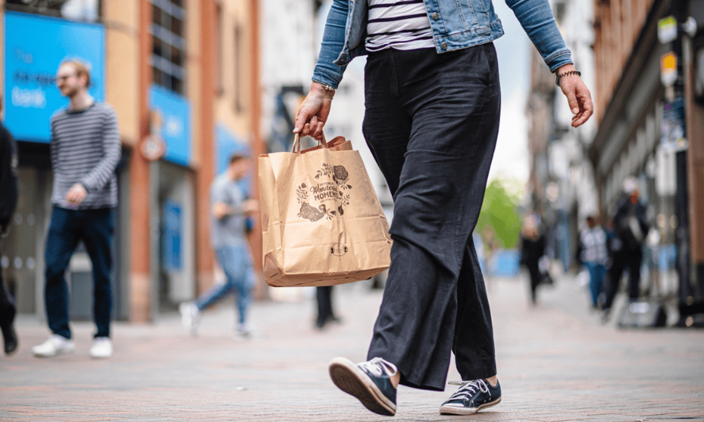 The lower half of a woman carrying a paper shopping bag near to Old Market Square, Nottingham