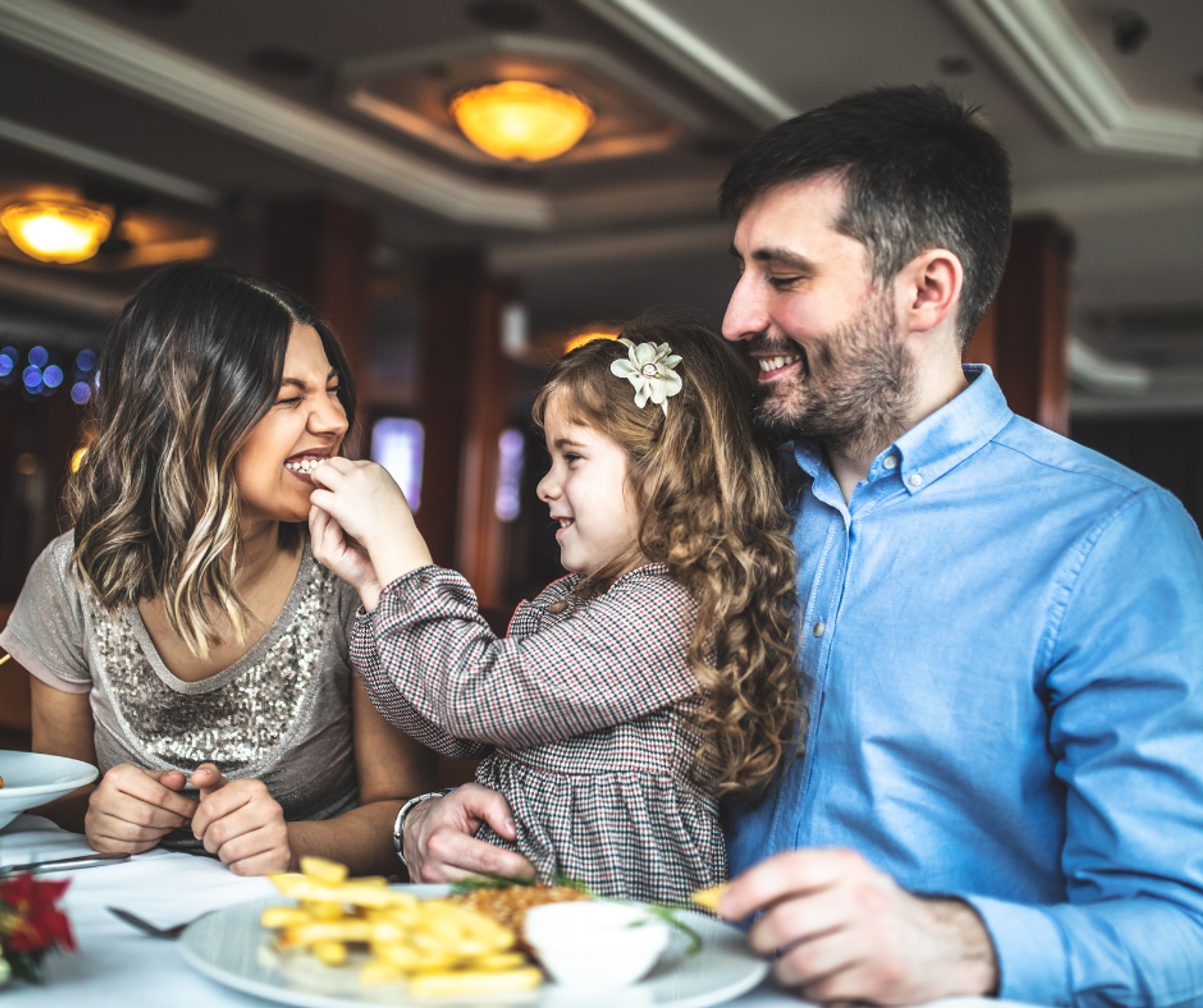 Two parents and a young girl eating out at a family restaurant