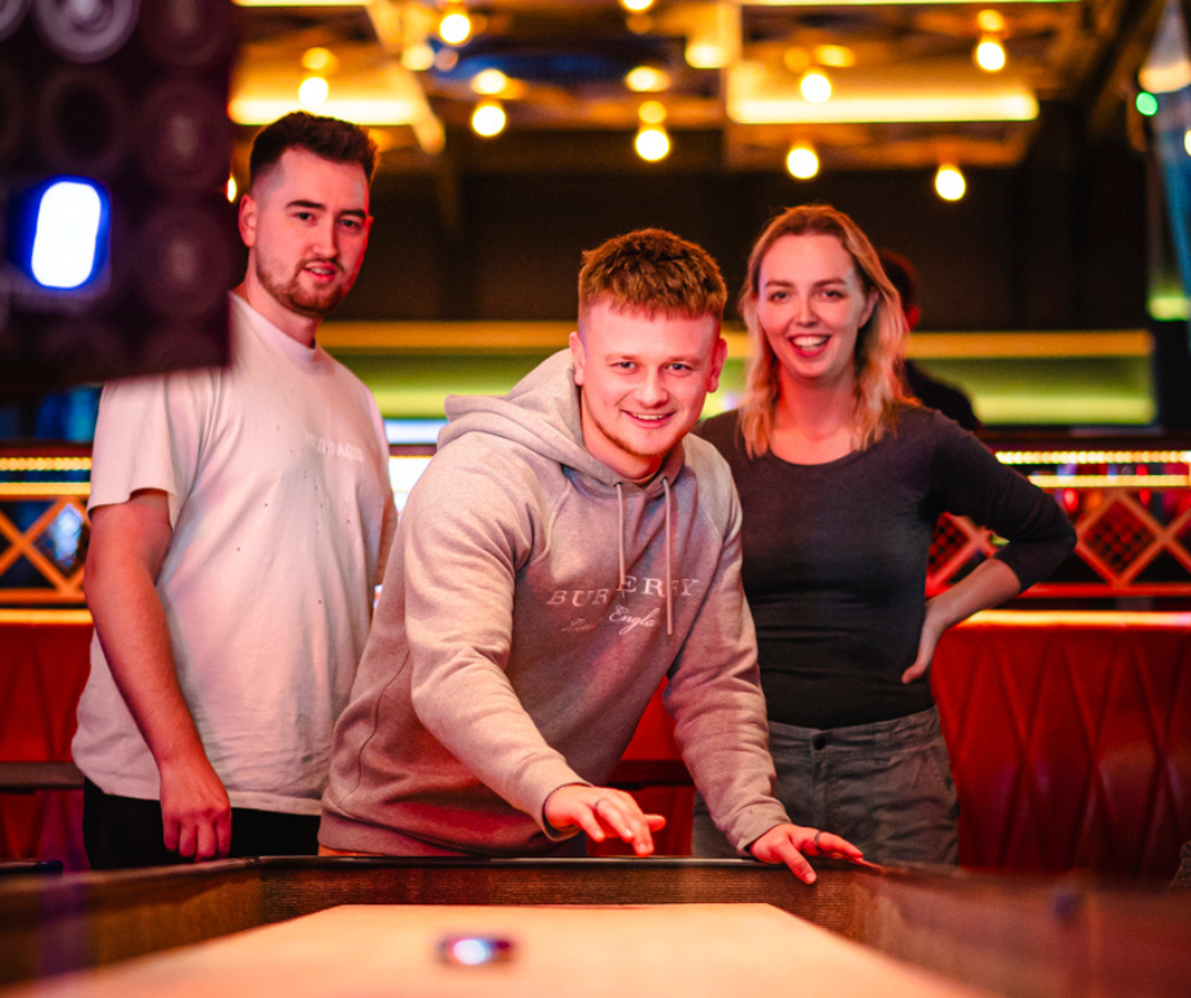Two men and a woman playing a table game in a night out in Nottingham